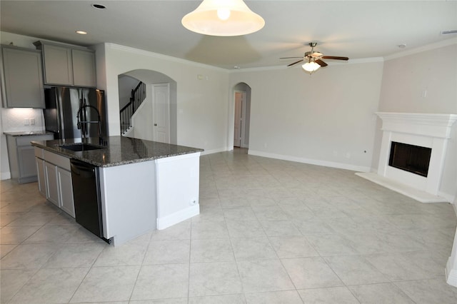 kitchen featuring a center island with sink, crown molding, gray cabinetry, and black appliances