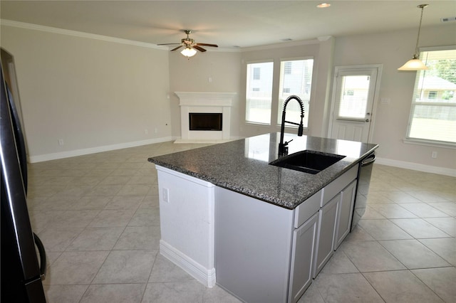 kitchen with light tile patterned flooring, sink, decorative light fixtures, dark stone counters, and black appliances