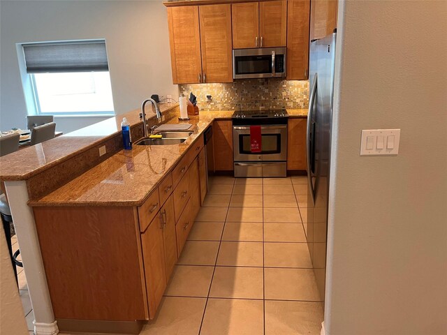 301 E Houston St Unit 3301, Port Isabel, TX 78578 - kitchen with stainless steel appliances, a sink, a peninsula, tasteful backsplash, and brown cabinets