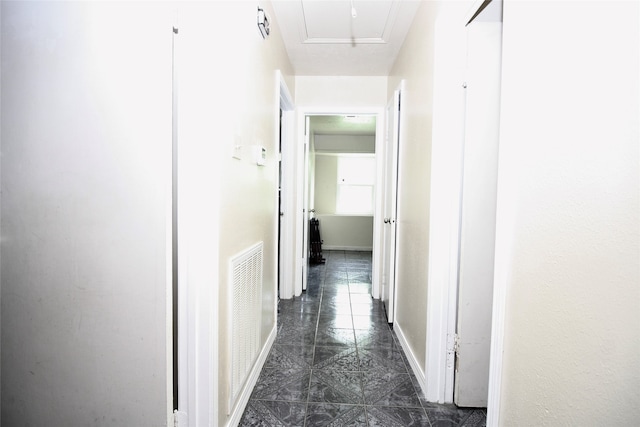 hallway featuring dark tile patterned flooring