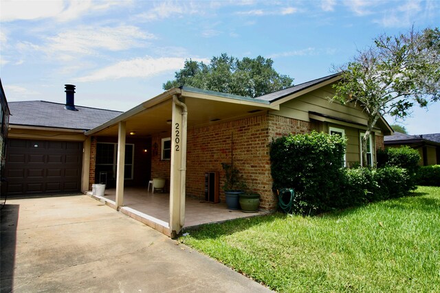 view of side of home featuring a garage and a lawn