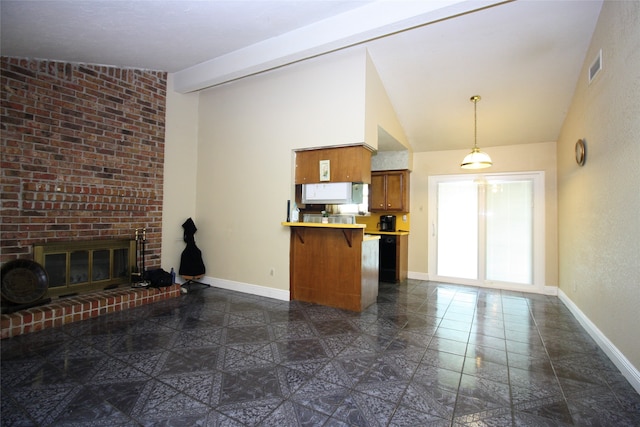 kitchen featuring dark tile patterned floors, a breakfast bar, vaulted ceiling with beams, kitchen peninsula, and a brick fireplace