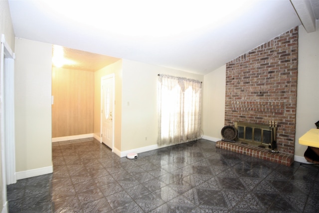 unfurnished living room featuring brick wall, dark tile patterned floors, a brick fireplace, and vaulted ceiling with beams