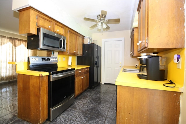2202 Jones St, Rosenberg, TX 77471 - kitchen with appliances with stainless steel finishes, light countertops, ceiling fan, brown cabinets, and a sink