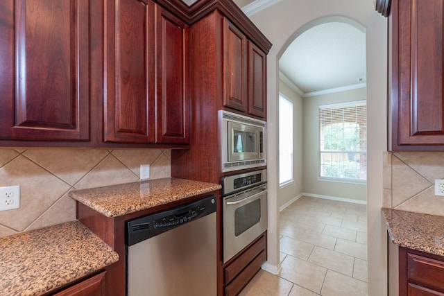 kitchen featuring arched walkways, decorative backsplash, appliances with stainless steel finishes, crown molding, and stone counters