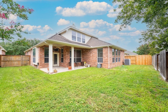 back of house with brick siding, a patio, a fenced backyard, and a lawn