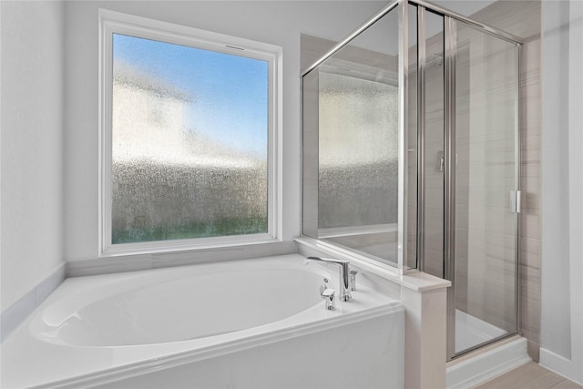 bathroom featuring independent shower and bath