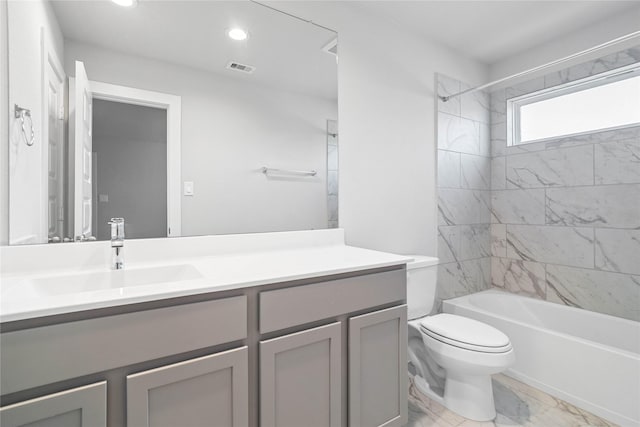 full bathroom with vanity, tiled shower / bath combo, and toilet