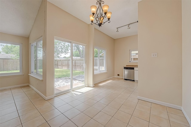 interior space with vaulted ceiling, a notable chandelier, light tile patterned flooring, and track lighting