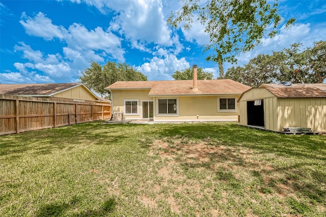 rear view of house with a patio area, a yard, and a storage shed