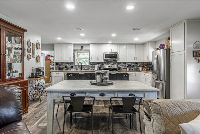 kitchen with white cabinets, wood-type flooring, appliances with stainless steel finishes, and sink