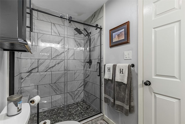 bathroom featuring toilet and a shower with door