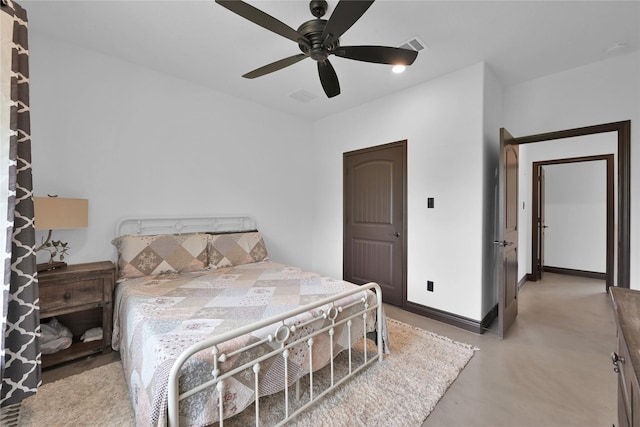 bedroom with ceiling fan and concrete flooring