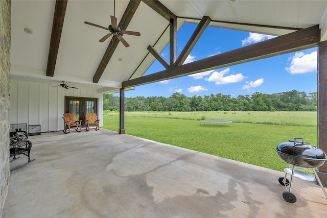 view of patio with ceiling fan, a trampoline, a rural view, and grilling area