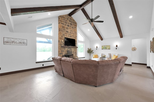 living room with ceiling fan, plenty of natural light, a stone fireplace, and high vaulted ceiling