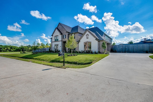 french country home featuring a front lawn