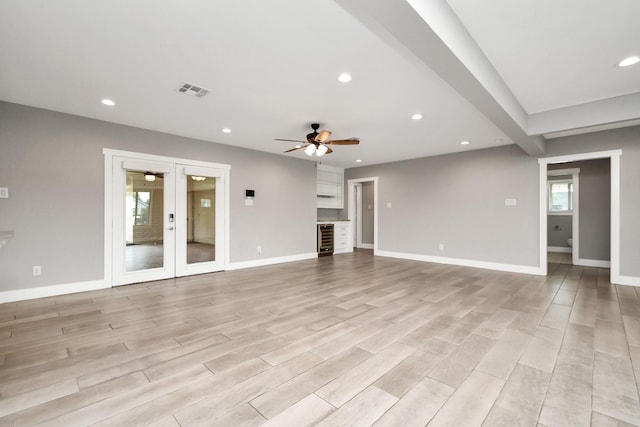 unfurnished living room featuring light hardwood / wood-style floors, beverage cooler, french doors, and ceiling fan