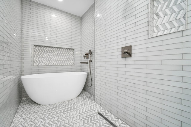 bathroom featuring tile walls, a bath, and tile patterned floors