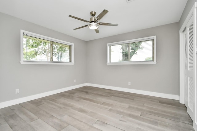 unfurnished bedroom with ceiling fan, a closet, and light wood-type flooring