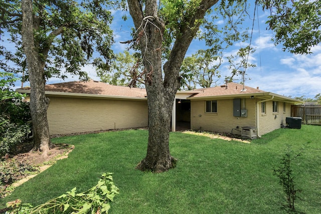 rear view of property with a yard and central AC unit