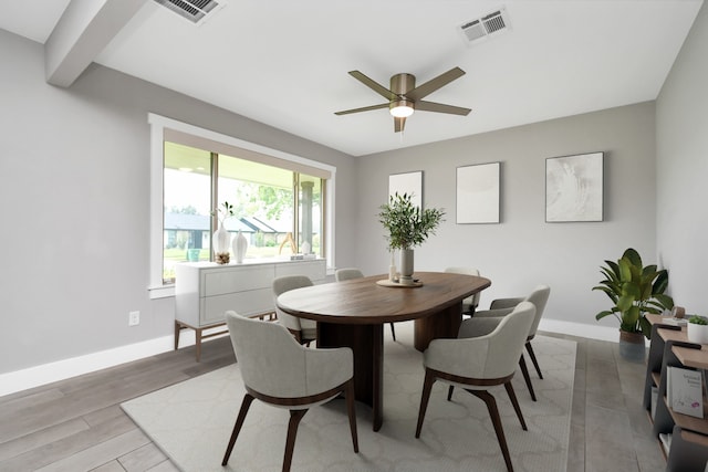 dining room featuring light hardwood / wood-style flooring, beamed ceiling, and ceiling fan