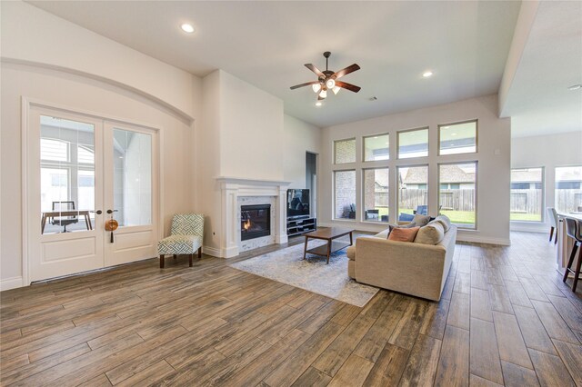 living room featuring a fireplace, french doors, hardwood / wood-style floors, and ceiling fan