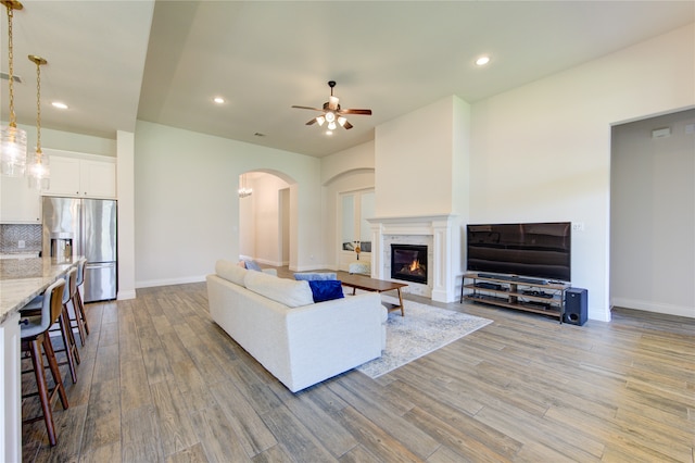 living room with a fireplace, hardwood / wood-style floors, and ceiling fan