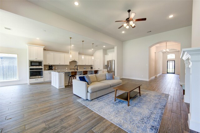 living room with sink, ceiling fan, and hardwood / wood-style floors