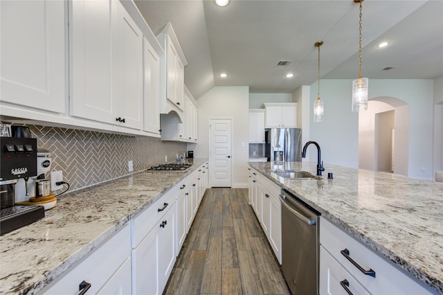 kitchen with dark hardwood / wood-style flooring, decorative backsplash, appliances with stainless steel finishes, white cabinetry, and decorative light fixtures