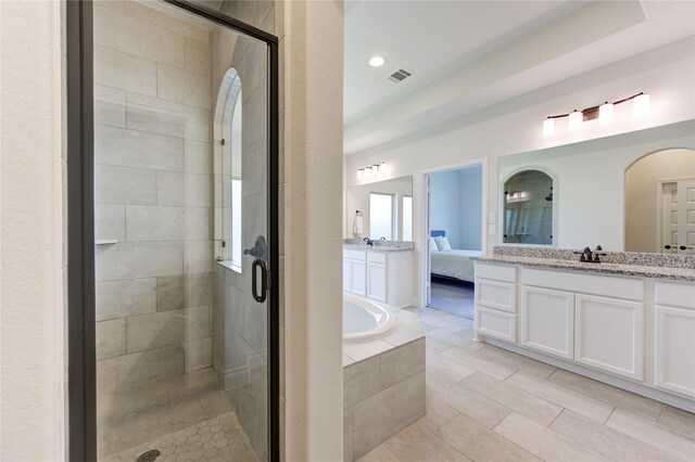 bathroom with shower with separate bathtub, a raised ceiling, vanity, and tile patterned flooring