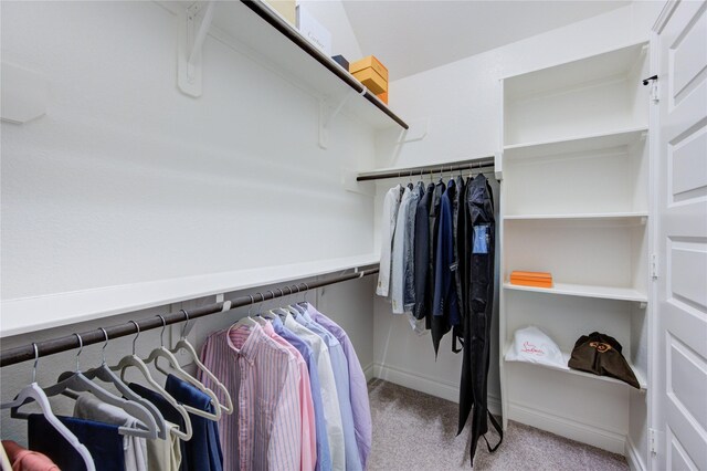 walk in closet featuring light carpet