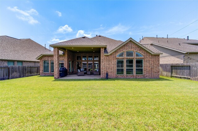 rear view of property featuring a patio area and a yard