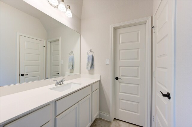 bathroom with tile patterned floors, vanity, and lofted ceiling