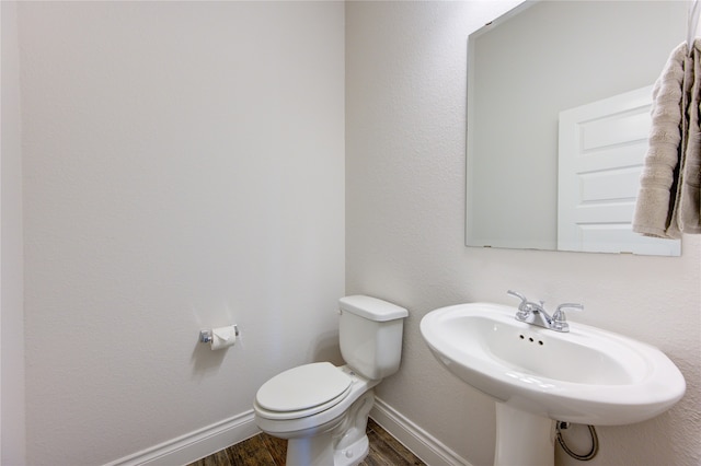 bathroom featuring sink, wood-type flooring, and toilet