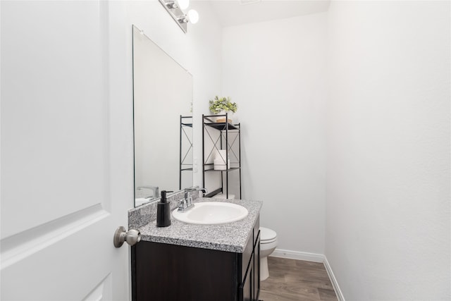 bathroom featuring hardwood / wood-style floors, vanity, and toilet