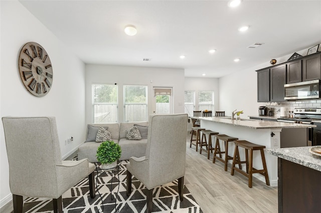 living room with light hardwood / wood-style floors and sink