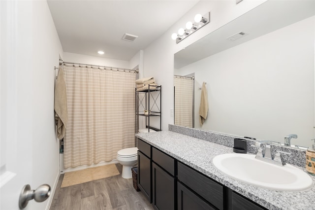 full bathroom featuring shower / tub combo with curtain, vanity, wood-type flooring, and toilet