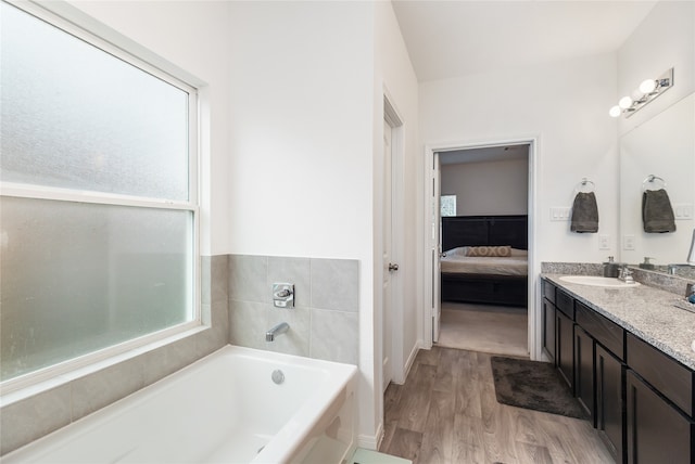 bathroom with hardwood / wood-style floors, vanity, and a washtub