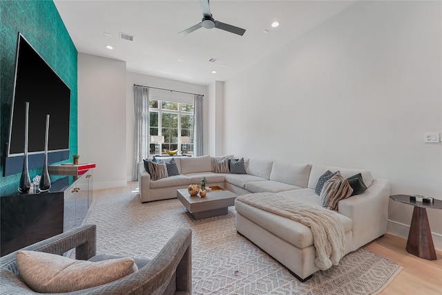 living room with light hardwood / wood-style flooring and ceiling fan