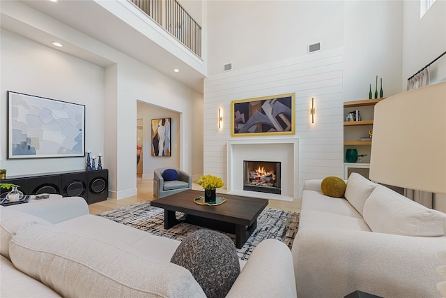 living room featuring a towering ceiling and built in shelves