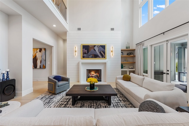 living room with a high ceiling and light hardwood / wood-style flooring