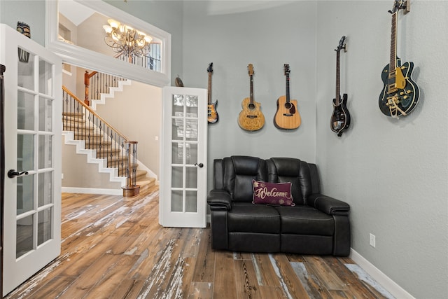 sitting room with wood-type flooring, a notable chandelier, and french doors