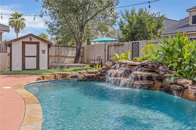 view of swimming pool with pool water feature and a storage shed