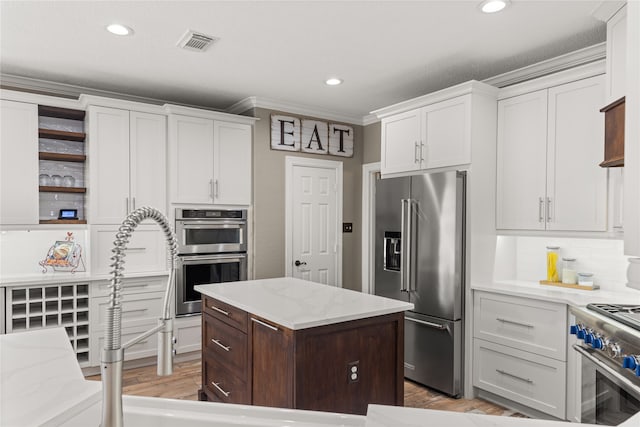 kitchen featuring white cabinetry, ornamental molding, a center island, and high quality appliances