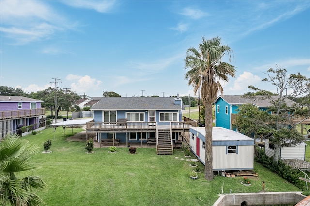 back of house featuring a wooden deck, a lawn, and a shed