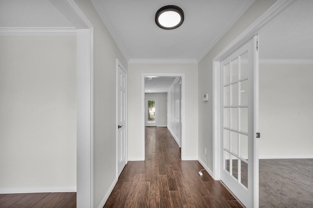 hallway with visible vents, dark wood-type flooring, baseboards, crown molding, and french doors