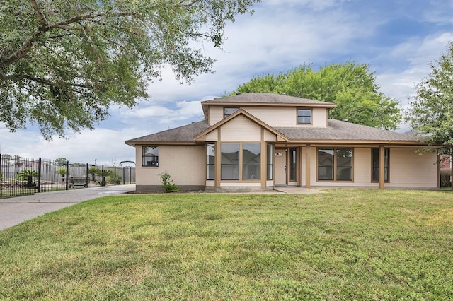 rear view of property featuring a yard and fence