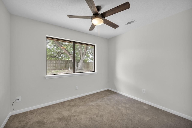 carpeted spare room with visible vents, a textured ceiling, and baseboards