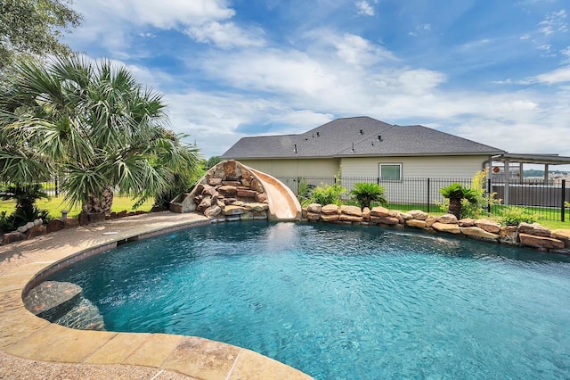 view of pool with a fenced in pool, a water slide, and fence