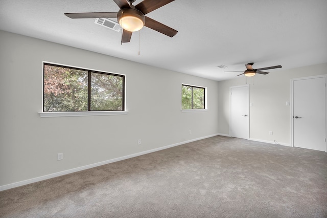 carpeted spare room featuring ceiling fan